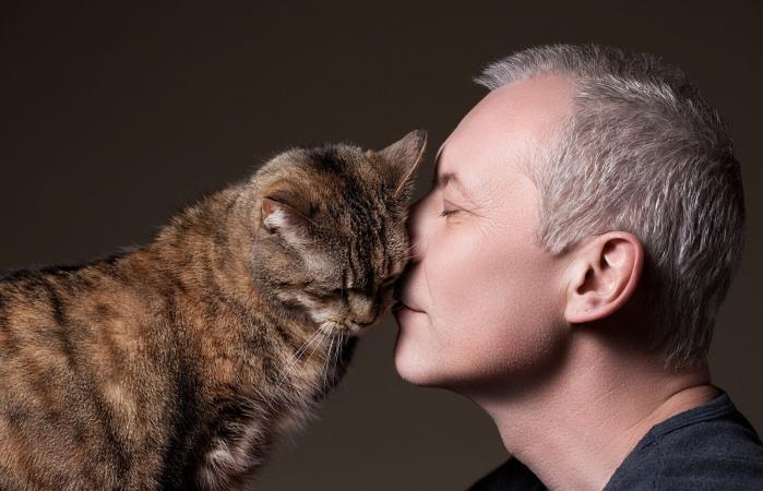 man and cat rubbing faces