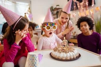 Little girl blowing her birthday candle 