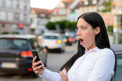 Astonished woman reading sms on mobile