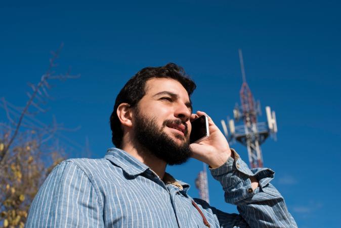 Man On Cellphone and Communication Tower