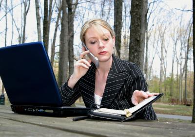 Businesswoman talking on phone while working outside
