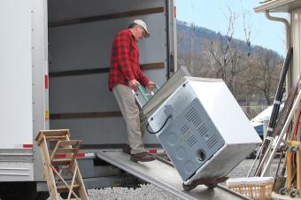 Man moving appliance on to truck