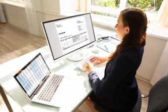 Woman working on invoices on computer