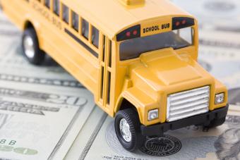 School bus toy on top of money