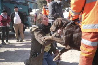 A woman holds her dog after the Turkey earthquake