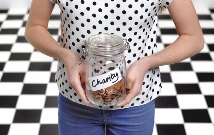 Girl holding a donation jar with coins