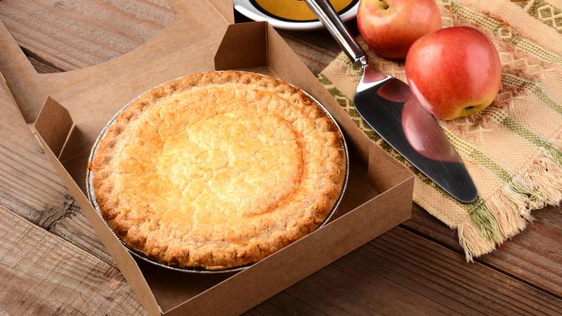 Freshly baked apple pie in a box on a wooden table