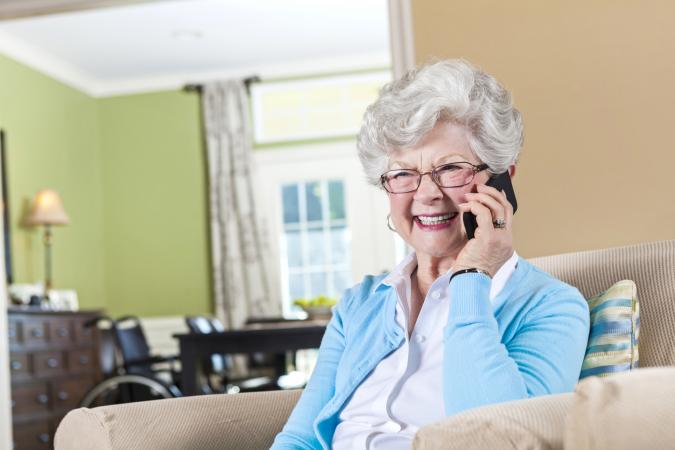 Elderly woman on phone appearing happy