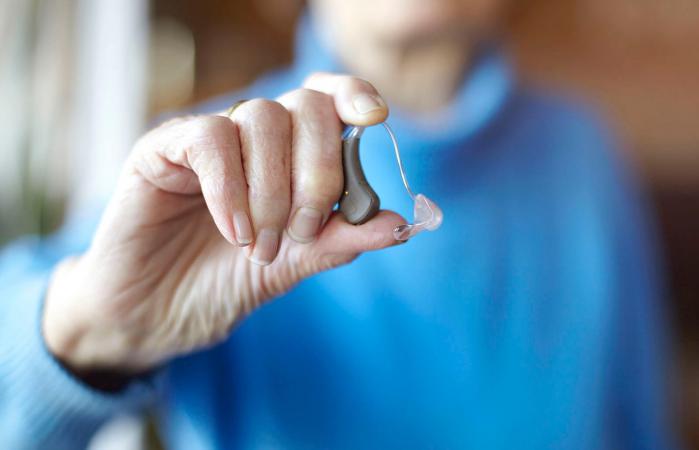 woman holding hearing aid