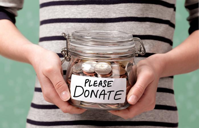 Child holding a charity donation jar