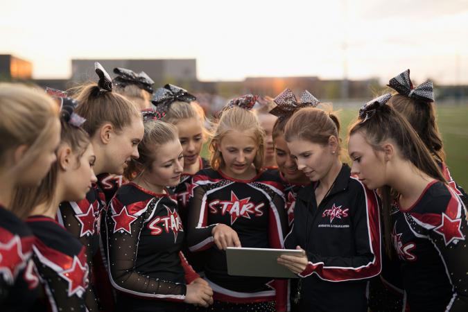 Cheerleading team using digital tablet