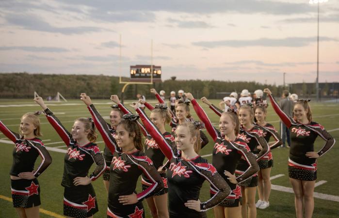 Cheerleaders cheering on football field