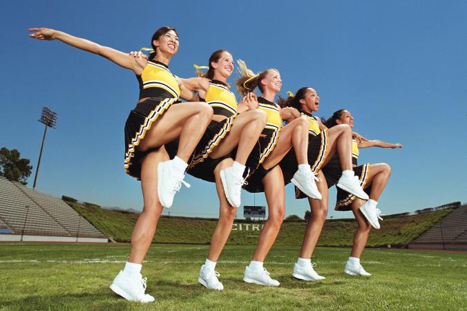Cheerleaders dancing arm in arm in formation
