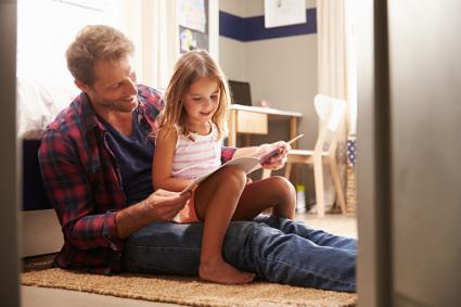 father and young daughter reading