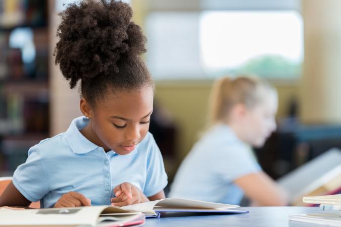 Girl reading book at school
