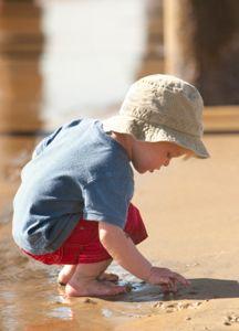 toddler in red shorts at beach