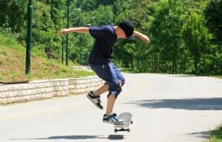 Skateboarding boy in jean shorts and a tee