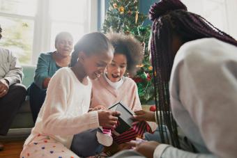 Excited sisters opening Christmas presents at home