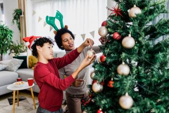 Boy decorating Christmas tree with his mother