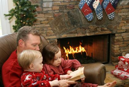 Dad and children reading by fireplace