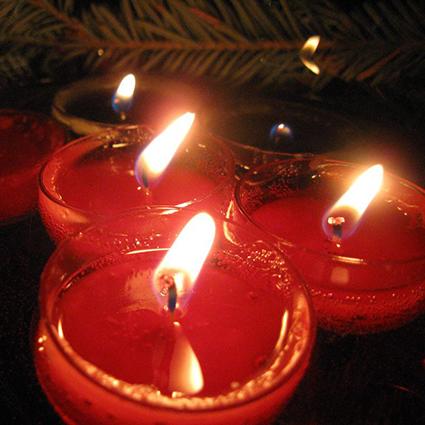Red floating candles with pine sprig background