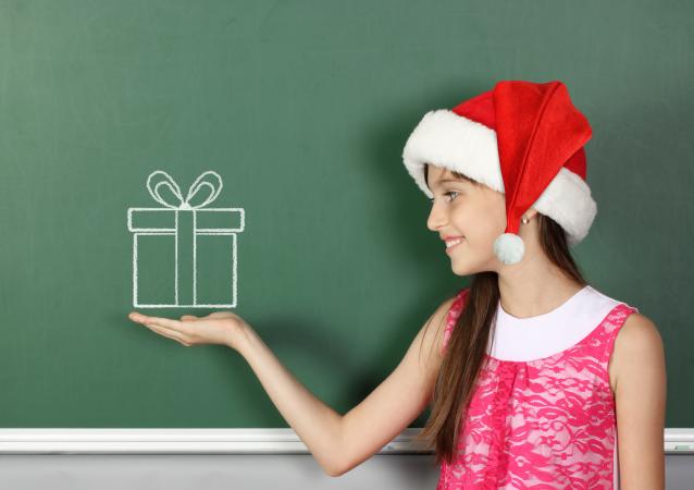 girl in Santa hat by chalkboard