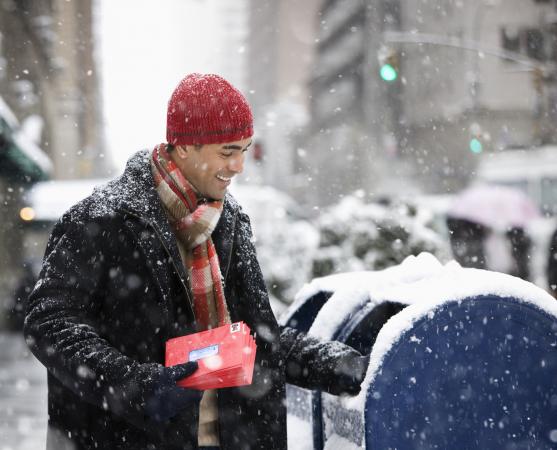 Bundled man mailing Christmas cards