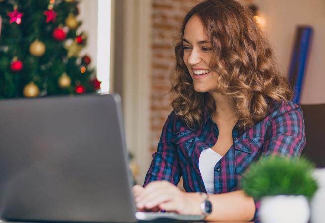 Woman on laptop writing Christmas newsletter
