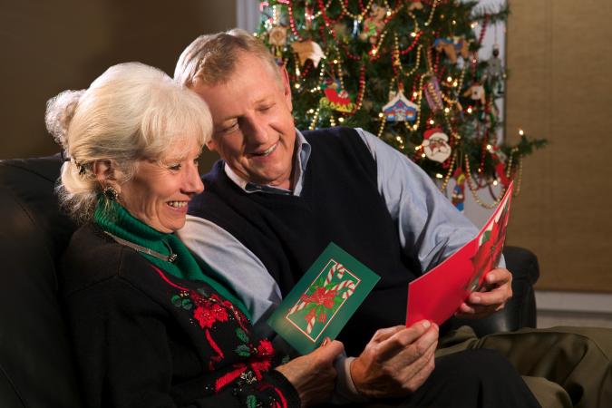 Couple enjoying reading Christmas greeting cards