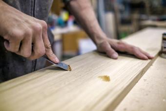 Scraping with putty knife on wood