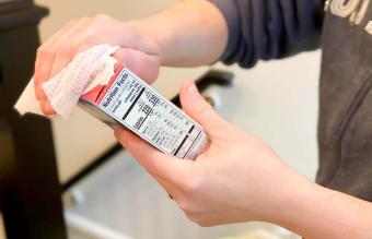 man sanitizing groceries