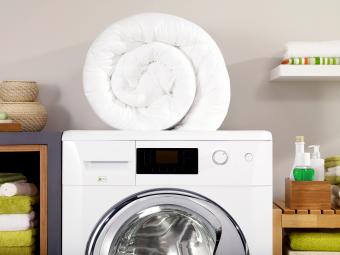 Folded down comforter on a washer in a laundry room