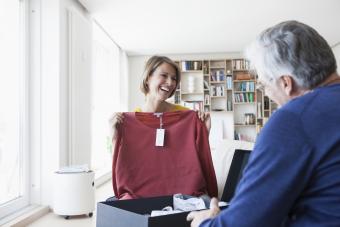 Woman holding up sweater for man to see