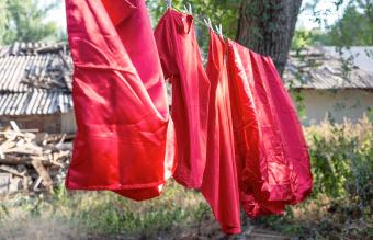 red silk bedding hanging outside 