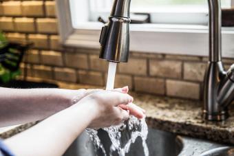 person washing hands in kitchen 