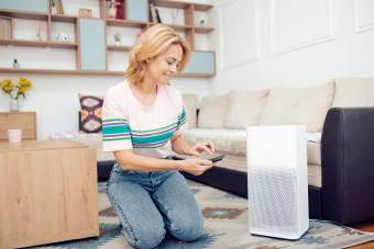 Woman adjusting a home air cleaner