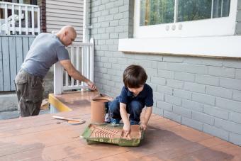 Father and son working together to paint the front porch