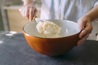 Female Baker Mixing Butter with a Whisk in a Domestic Kitchen