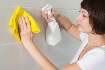 woman cleaning grout in shower