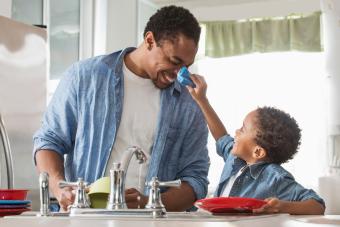 Father and son washing dishes in kitchen