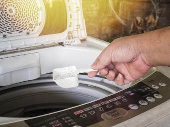 measuring detergent into the washer