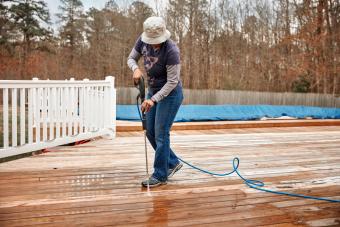 Woman powerwashing deck