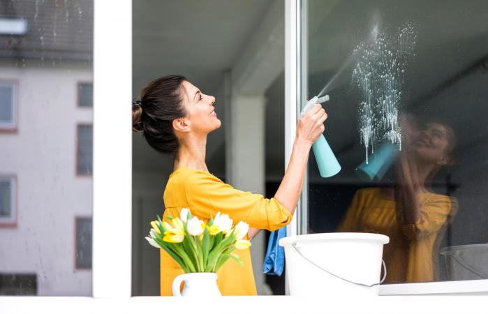 Woman at home cleaning the window