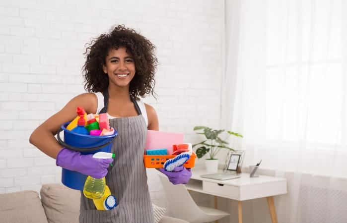 woman posing with cleaning supplies