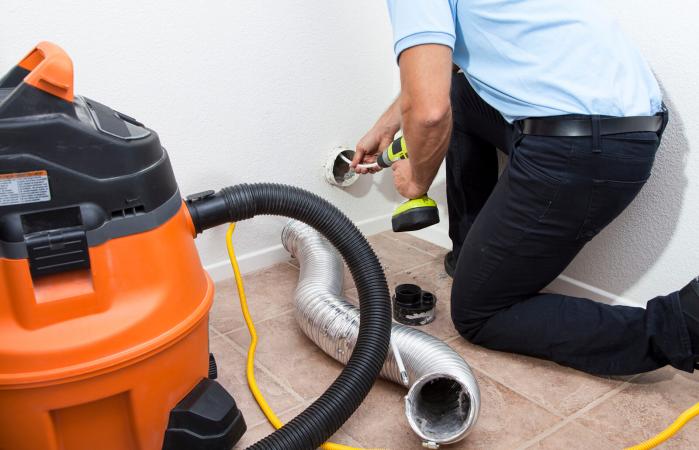 Man cleaning dryer vent