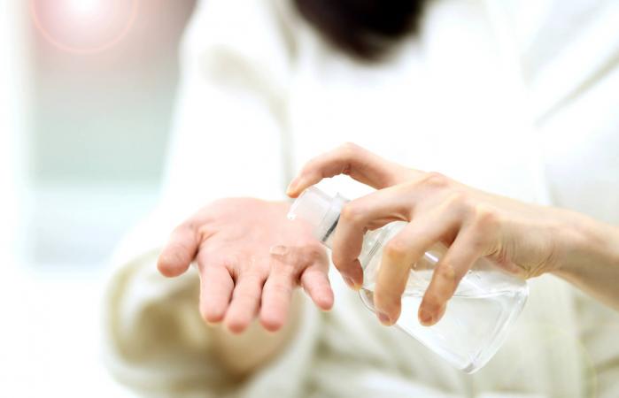 woman taking on hands liquid soap