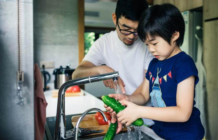 Father and son washing fresh fruit
