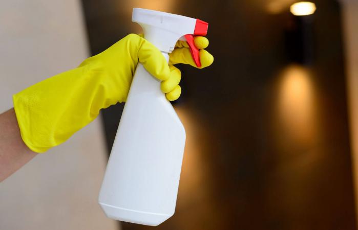 Hand holding detergent spray bottle