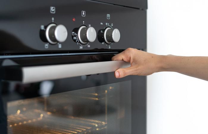 woman setting self-cleaning oven