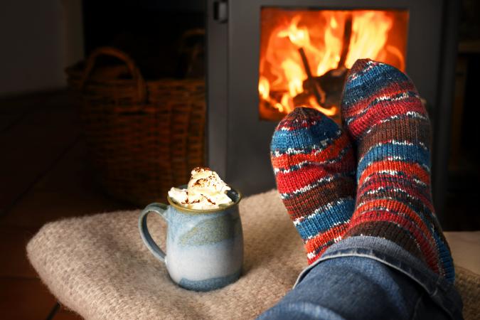 Person hearing wool socks against fireplace